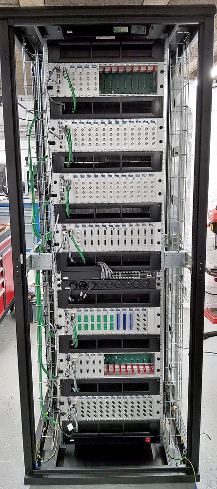 Front of the assembled bay: seven Gantner acquisition racks with their connectors, network switch and power strip.